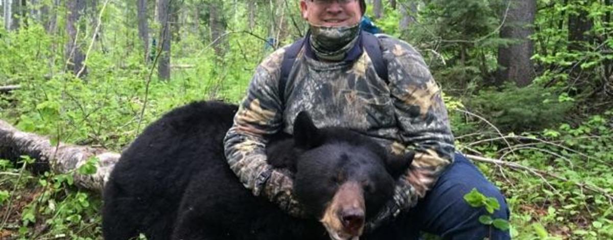 man with his black bear 